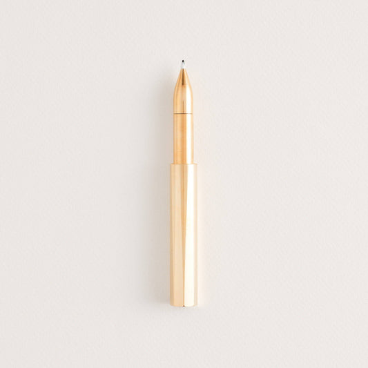 Brass refillable writing pen with exposed copper nib and pointed tip.