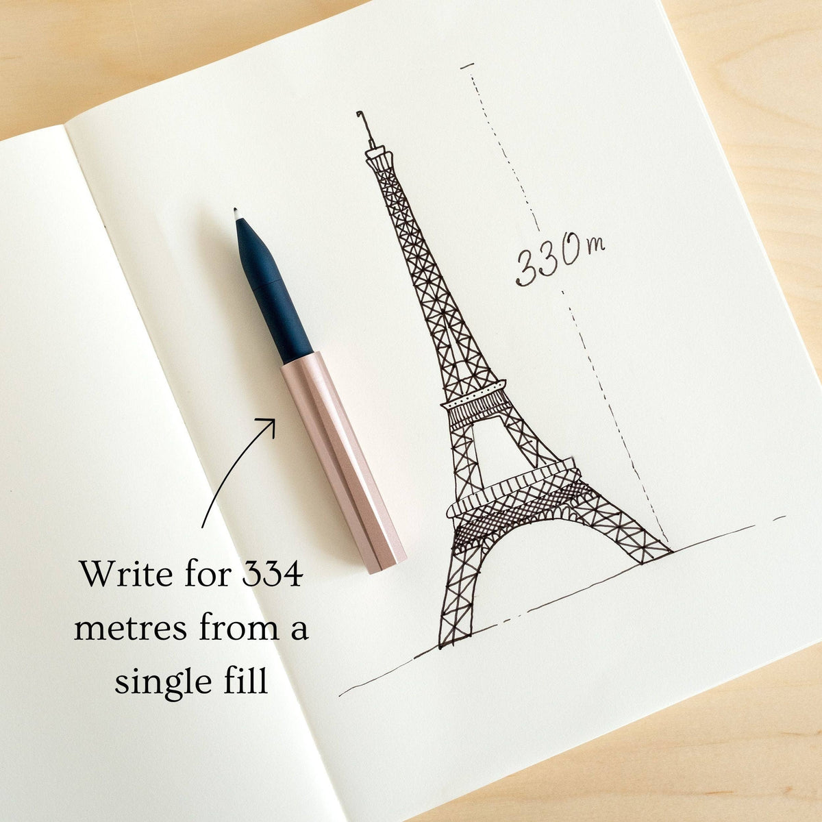 Pink fountain pen on paper with Eiffel Tower line drawing and measurement marks.