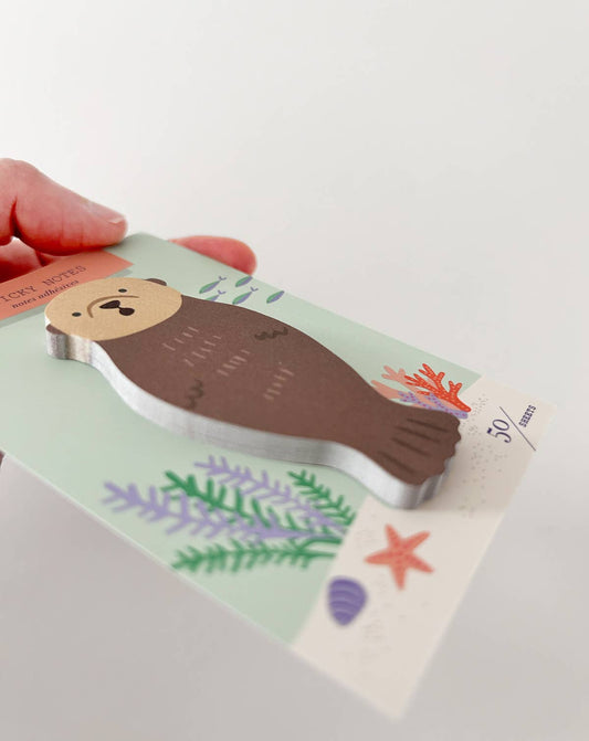 Sea otter die-cut sticky note held in hand with undersea scene