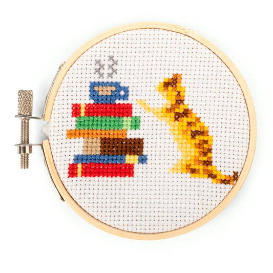 Round fabric embroidery hoop with cross-stitch cat and striped basket design
