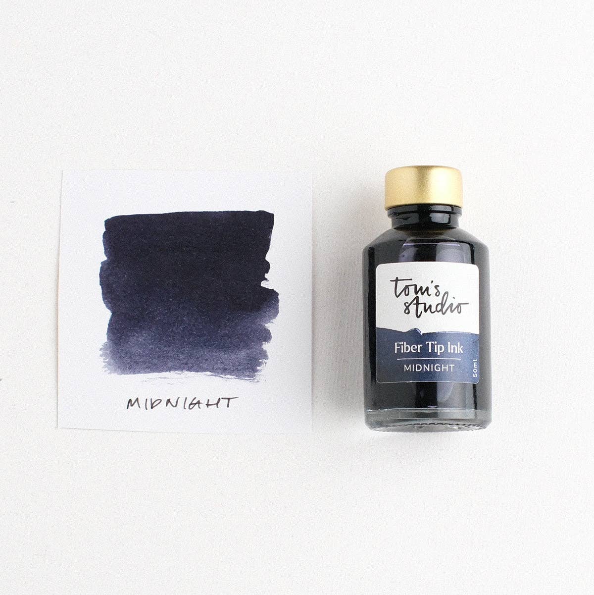 Midnight fibre tip ink bottle with label, clear ink reservoir and gold cap