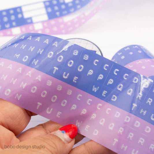 Embossed letters PET tape strip on clear backing with blue and lavender alphabet designs
