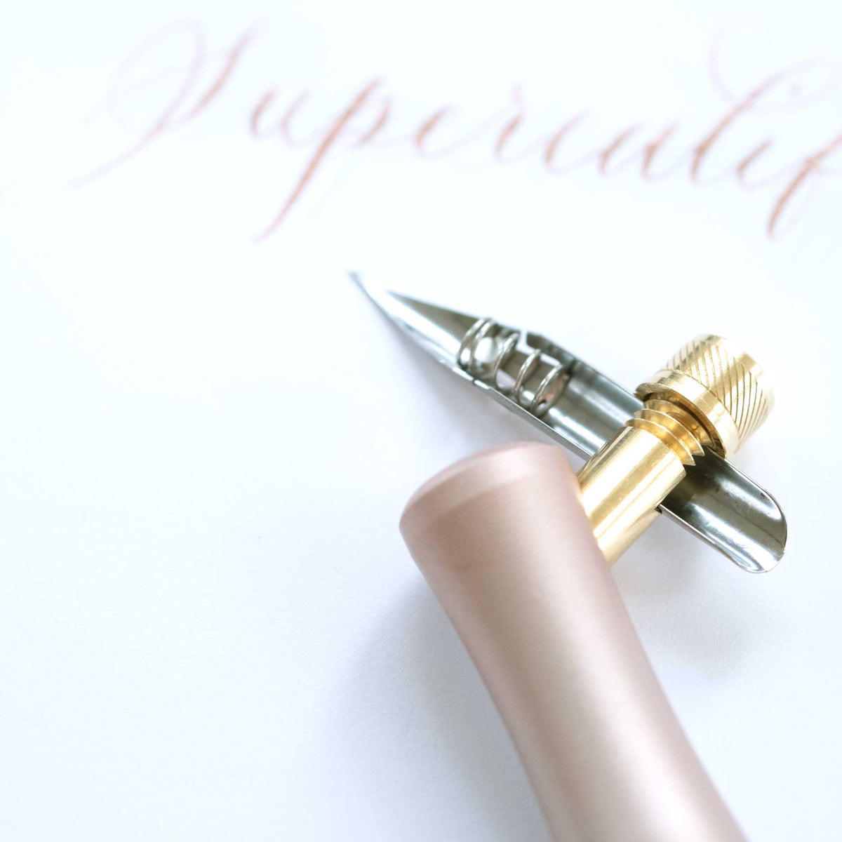 One Dip Wonder applicator pen with rose-gold barrel and silver pointed tip