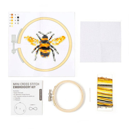 Cross-stitch kit contents: hoop with bee design, fabric, threads, needle, and instructions