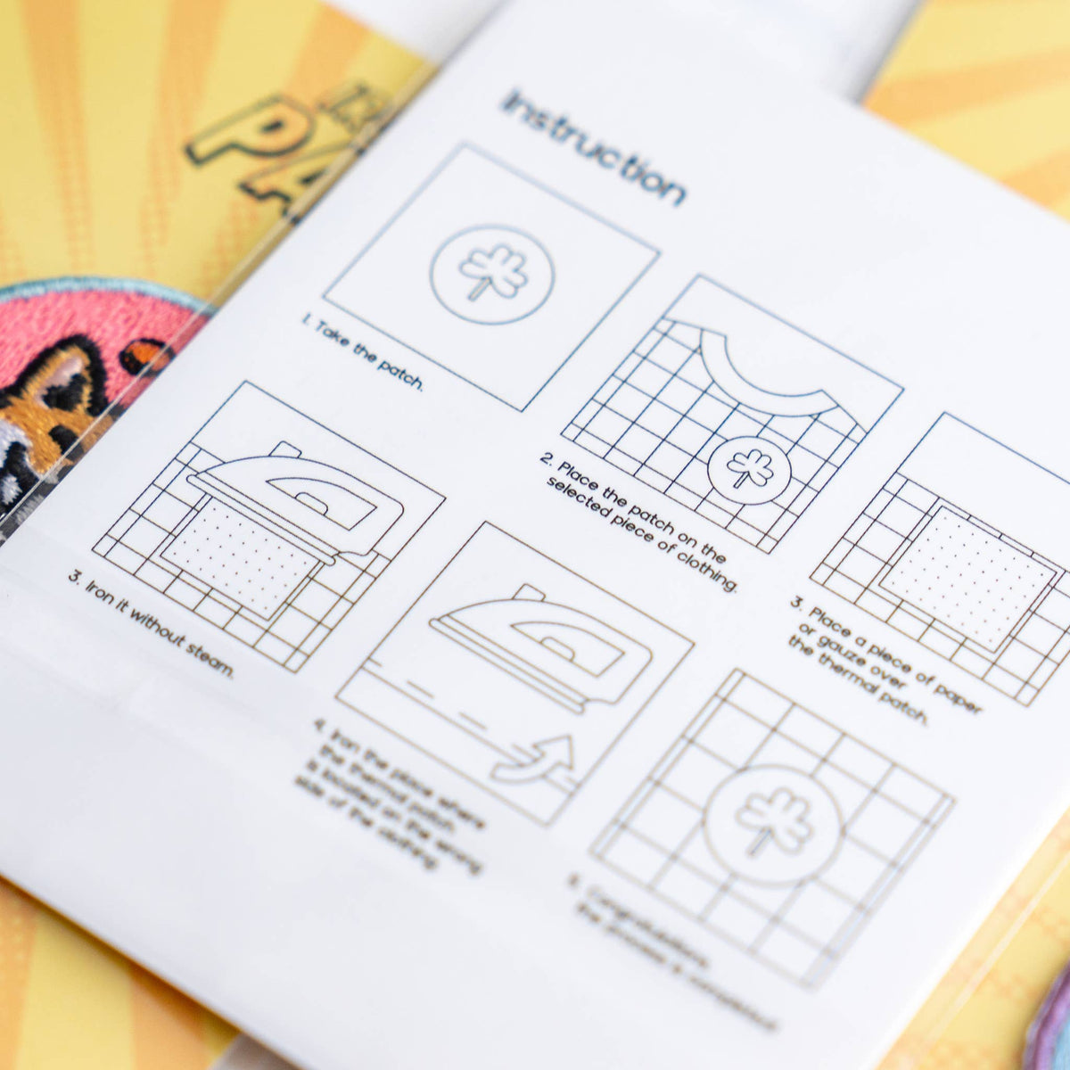 Iron-on patch instruction sheet with step diagrams and tools icons