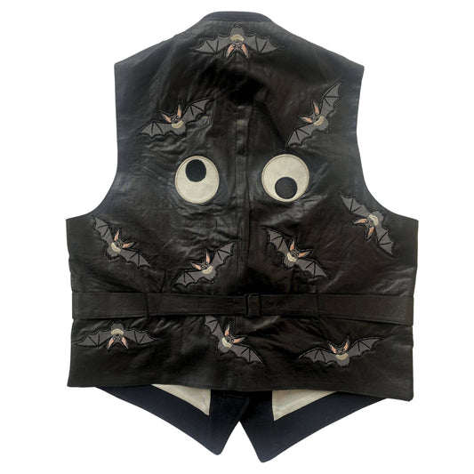 Black sleeveless jacket with bat patches and stitched round-eyed faces