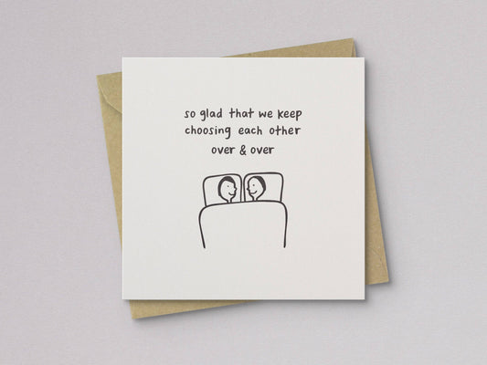 Letterpress love card with message and couple-in-bed line art, stacked on kraft envelope