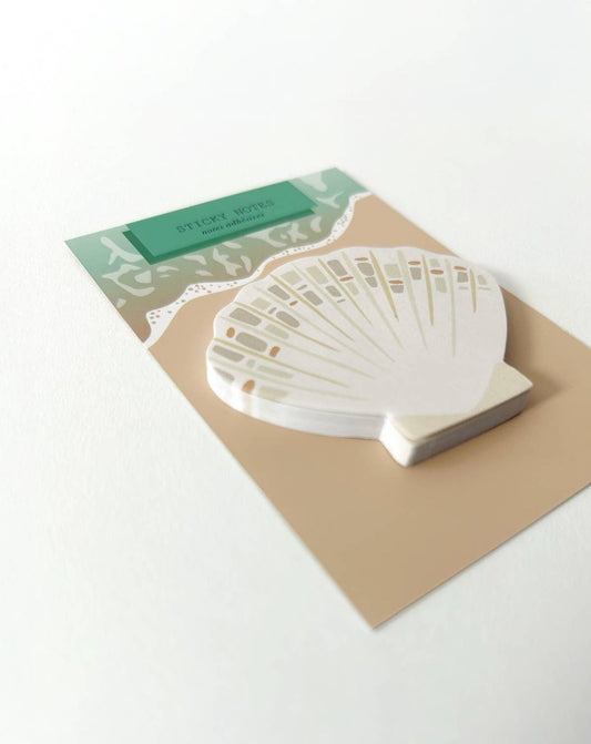 Seashell-shaped sticky note stack with green header, on kraft paper