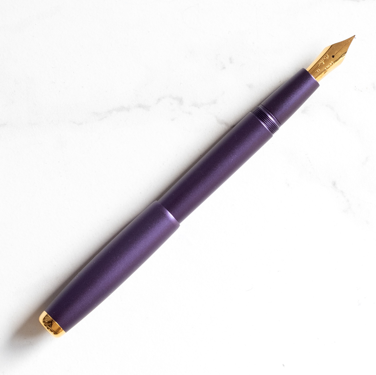 Fountain pen with dark purple barrel and gold nib