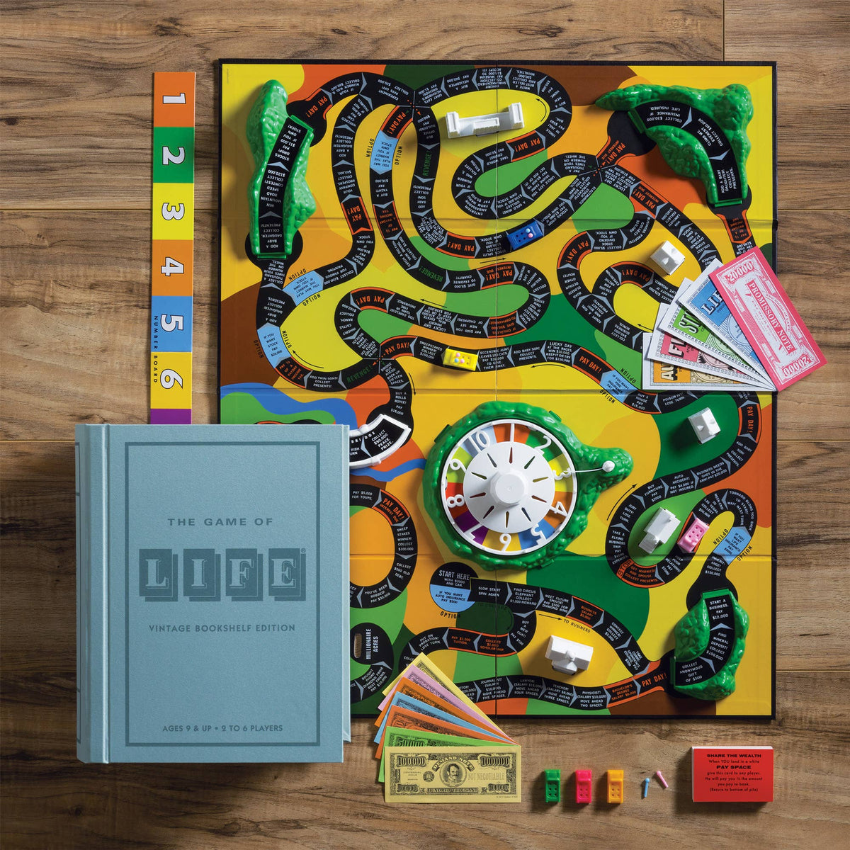 Open board game box showing colorful Life path board, pieces, and playing cards