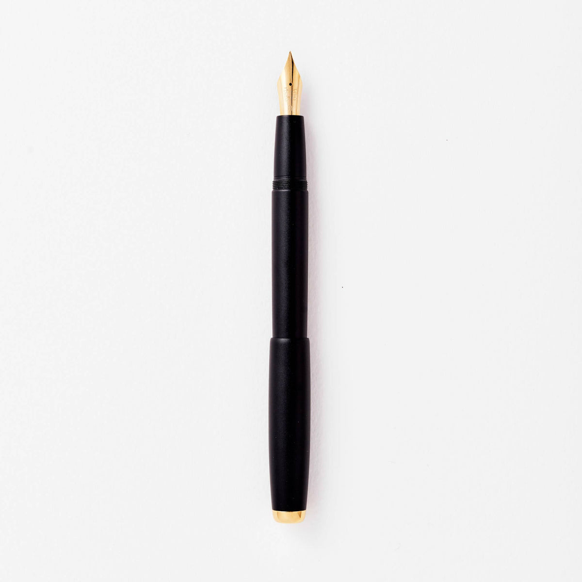 Black fountain pen with gold nib, shown uncapped.