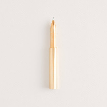 Brass refillable writing pen with exposed copper nib and pointed tip.