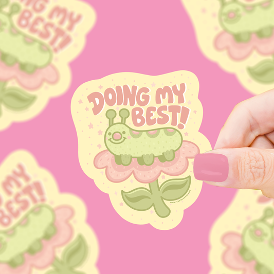 Green cartoon bug vinyl sticker with “DOING MY BEST” text, held on a hand