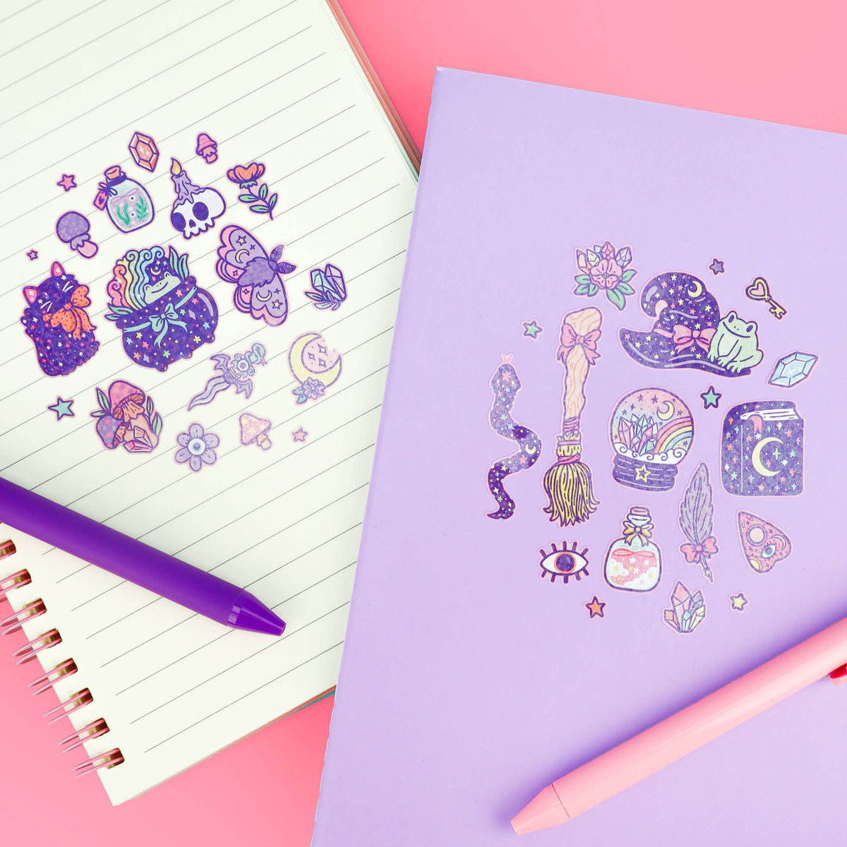 Sticker sheet with witch, wand, potion, and skull designs, next to notebook