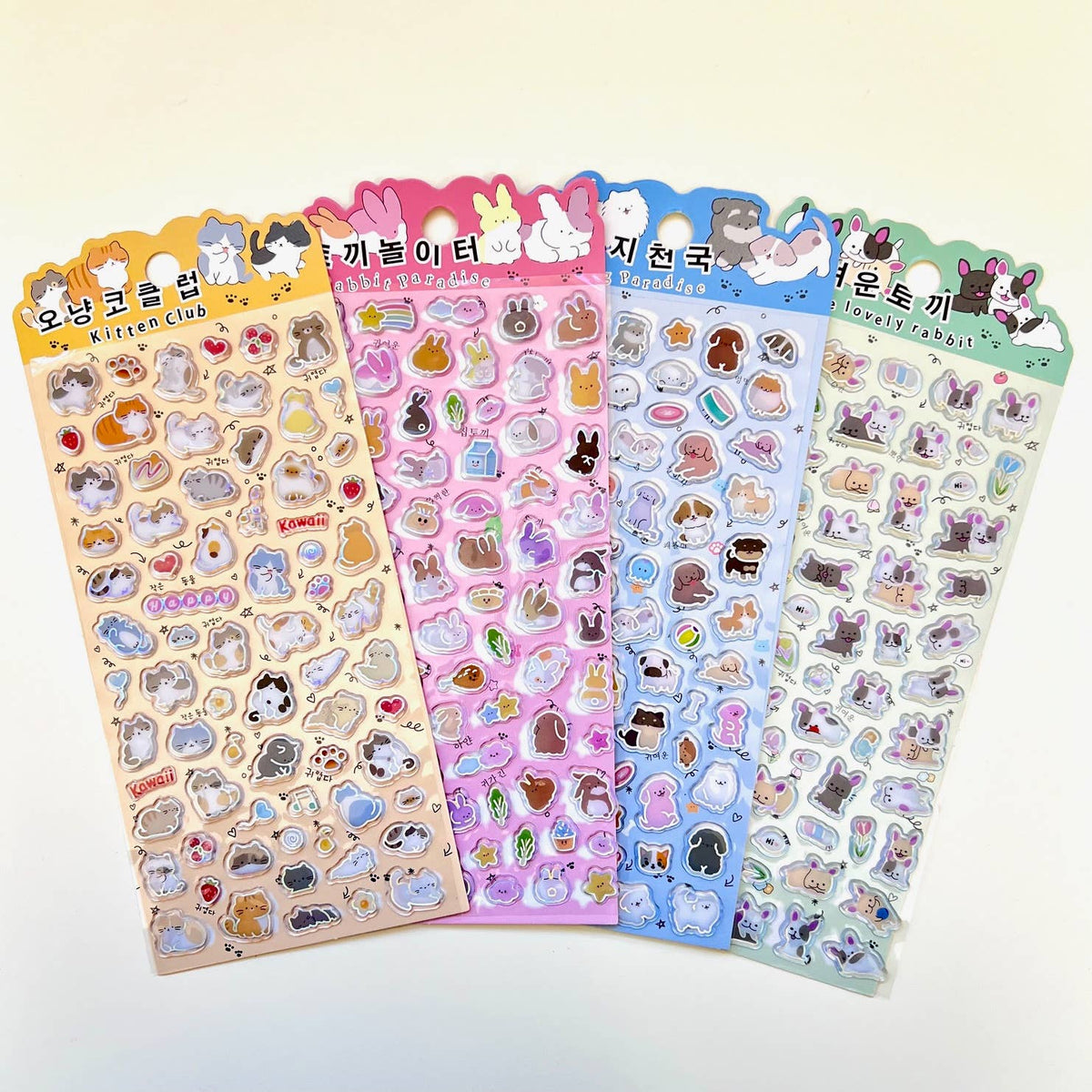 Assorted pastel sticker sheets featuring cute animal characters with rainbow foil edges.