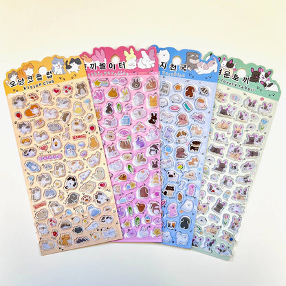 Assorted pastel sticker sheets featuring cute animal characters with rainbow foil edges.