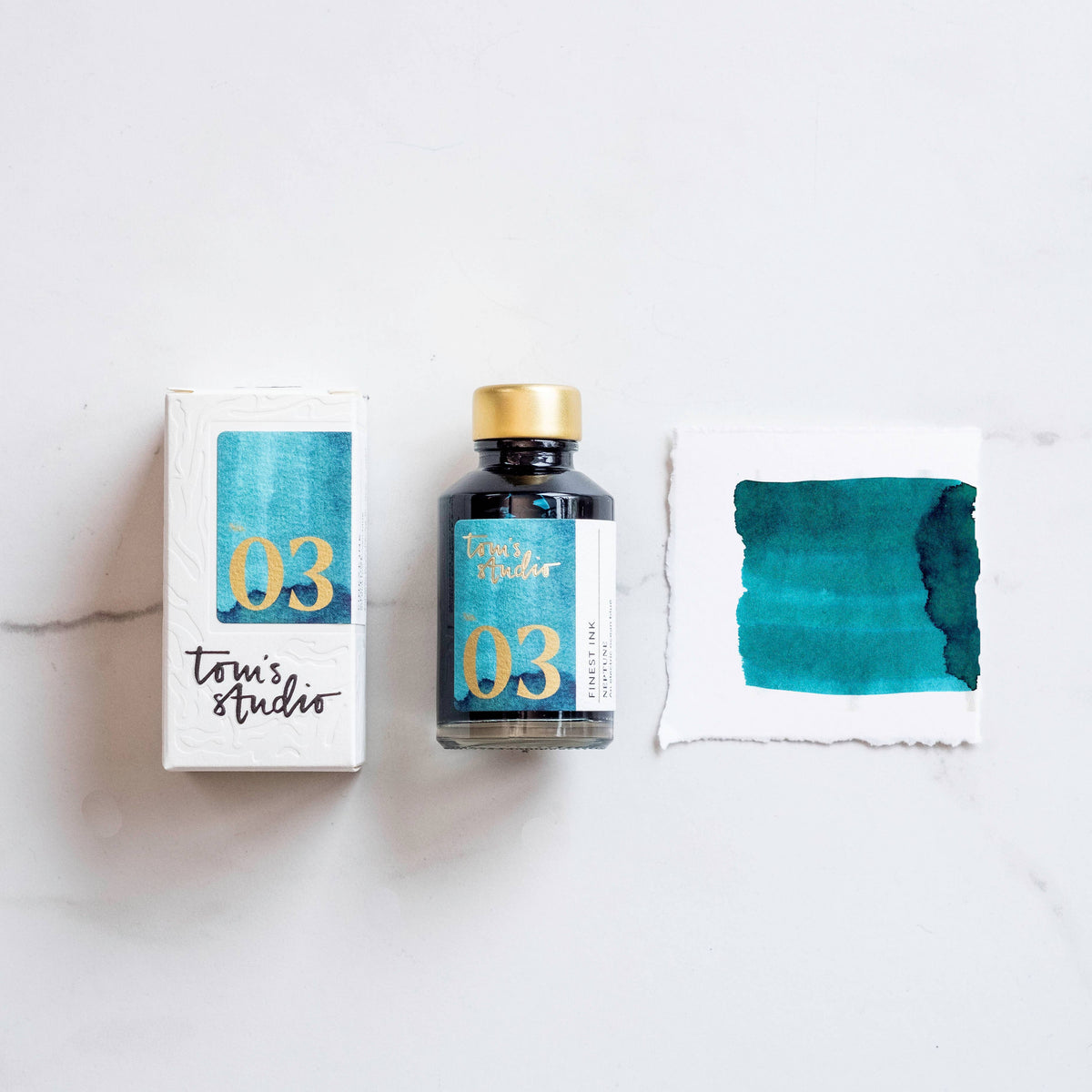 Neptune fountain pen ink bottle with gold cap and numbered 03 label, plus ink swatch