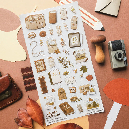 Sticker sheet on craft paper with pocket-watch, tag, leaf, and book icons