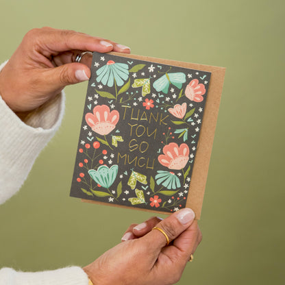 Floral thank-you greeting card with gold foil lettering, held open to show the design