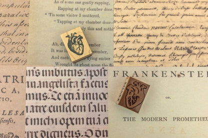 Wooden stamp block with carved face-like crest design on paper