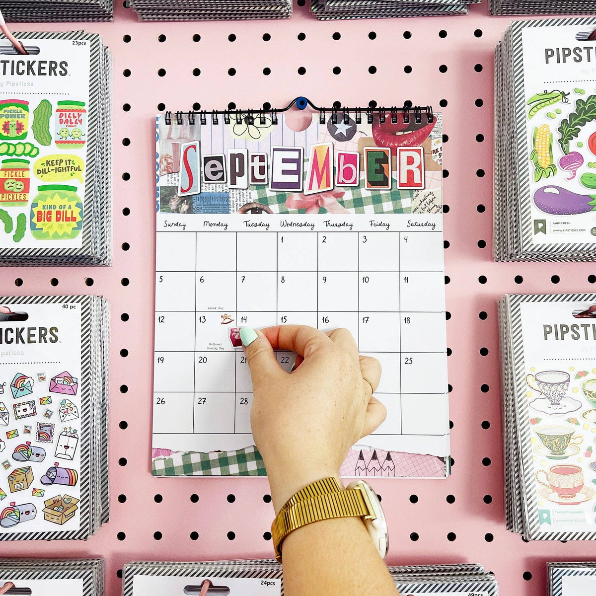 September wall calendar page with spiral binding, shown with a hand pointing at the dates.