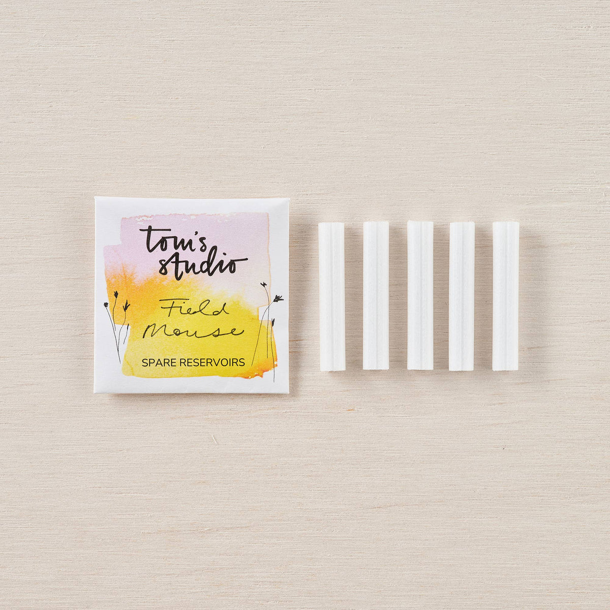 Spare ink reservoir set in white plastic sleeves, with branded paper pouch