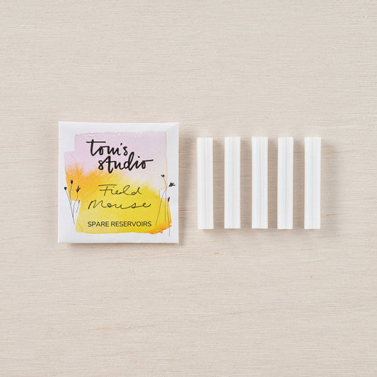Spare ink reservoir set in white plastic sleeves, with branded paper pouch