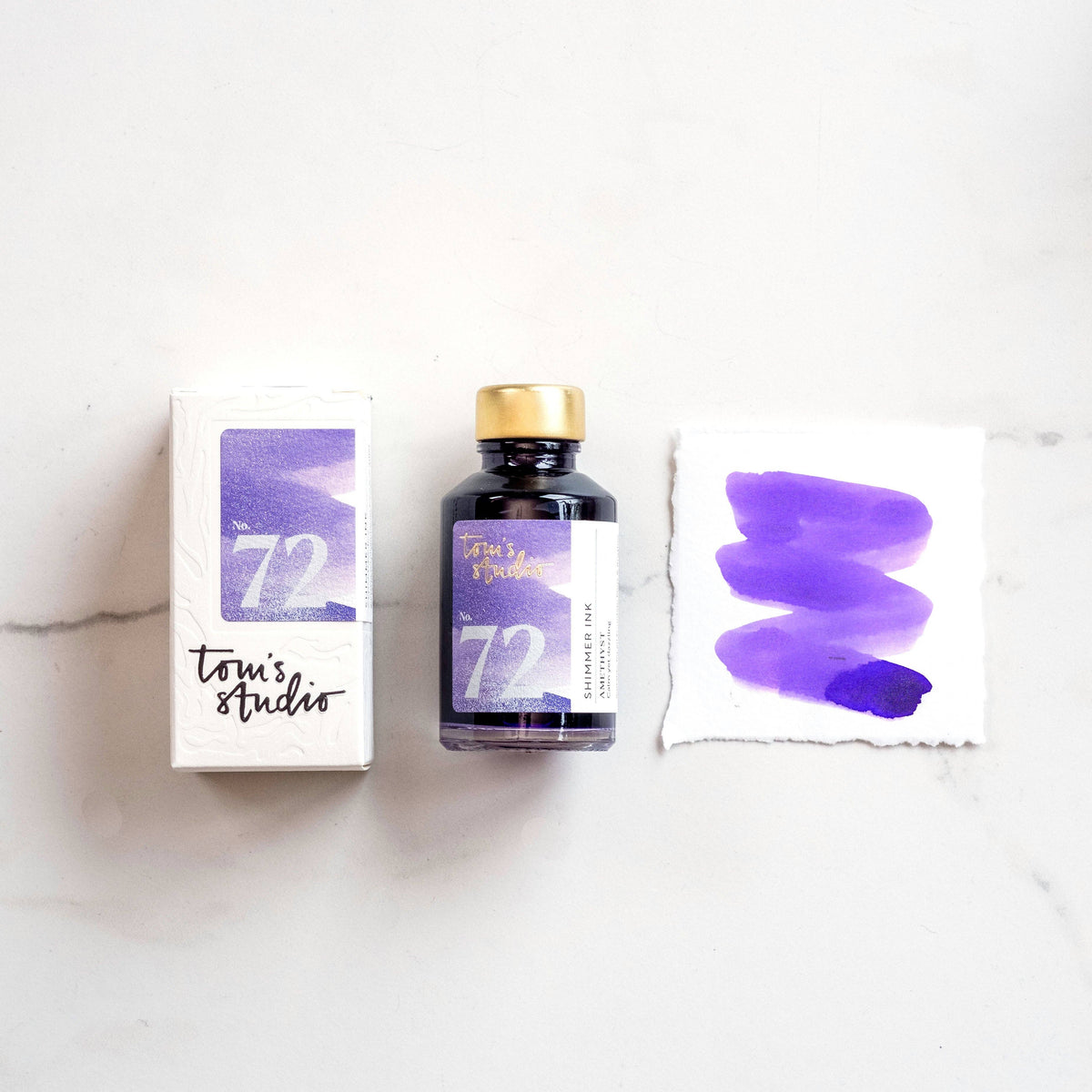 Shimmer ink bottle with amethyst purple label, boxed pack, and ink swatch