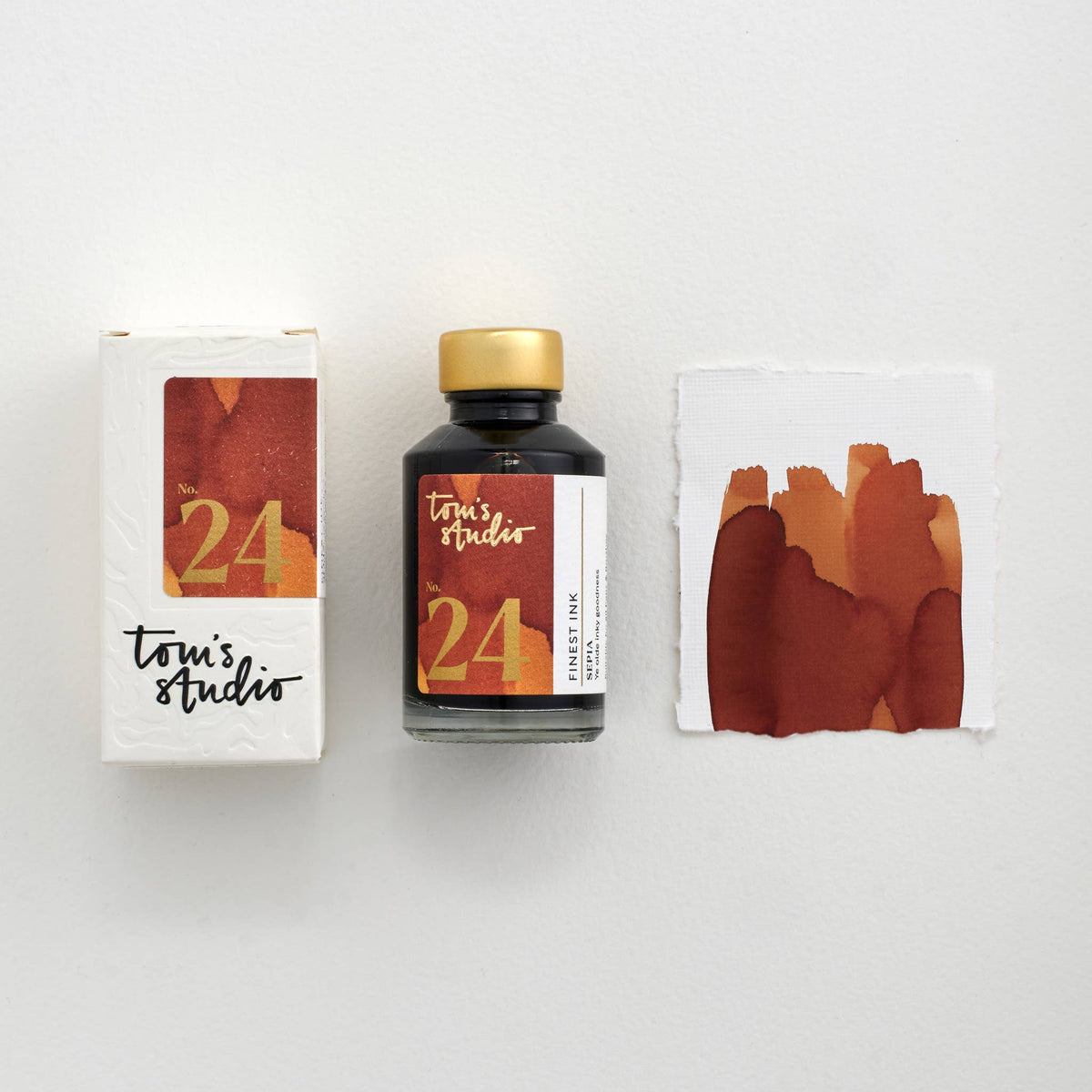 Sepia fountain pen ink bottle with gold cap and ink swatch cards
