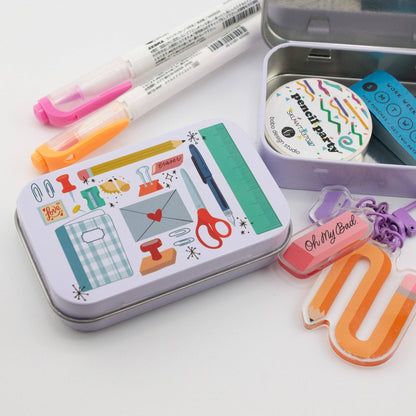 Stationery trinket tin with illustrated design, open tin, and colorful markers
