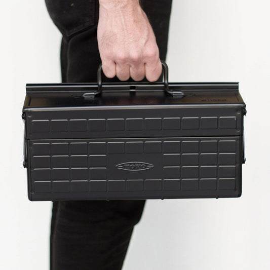 Black steel cantilever toolbox with textured brick pattern and carry handle.