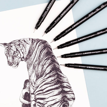 Black fine-tip drawing pens surrounding a detailed animal sketch on paper