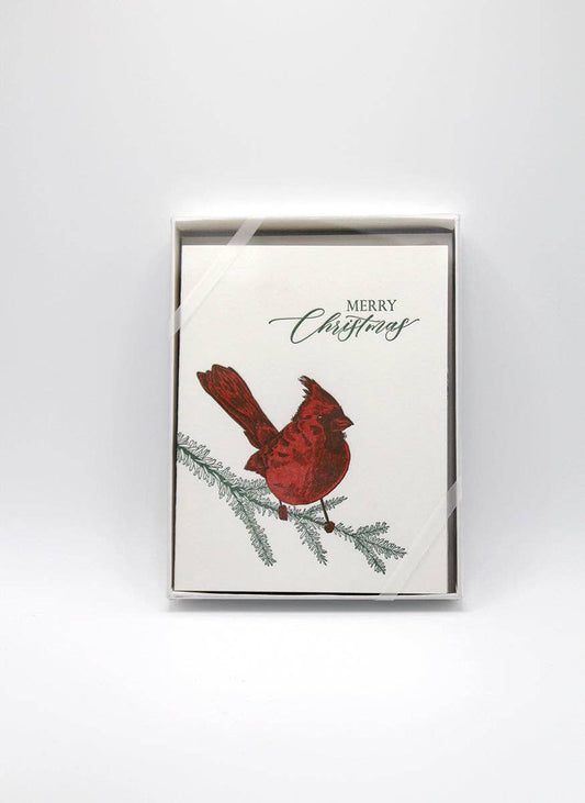 Boxed holiday letterpress card with red cardinal, green pine sprig, “Merry Christmas” text