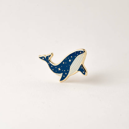Small blue whale enamel lapel pin with gold outline and white belly