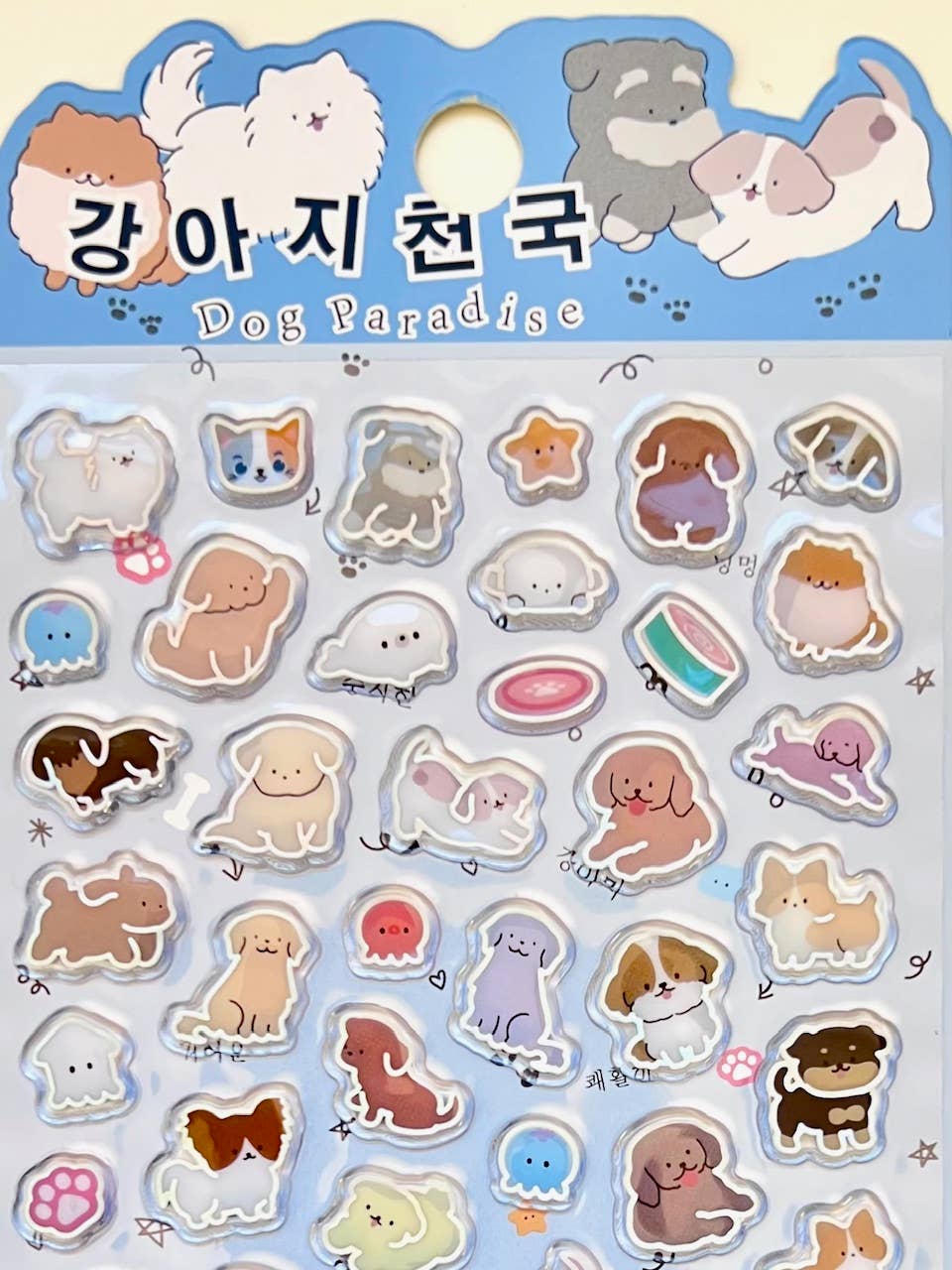 Dog Paradise sticker sheet with rounded dog faces, paws, bones, and hearts