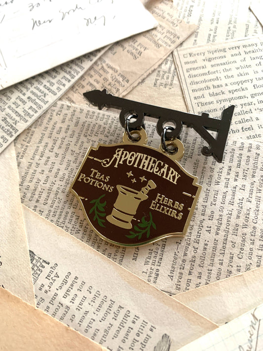 Apothecary shop enamel pin with Apothecary crest, potion bottles and herbs