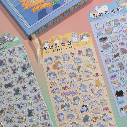 Sticker sheets with cute cat character icons, hearts, and holographic outlines in pastel tones.