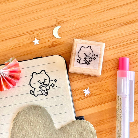 Wooden stamp block with cute boba cat line art on light wood