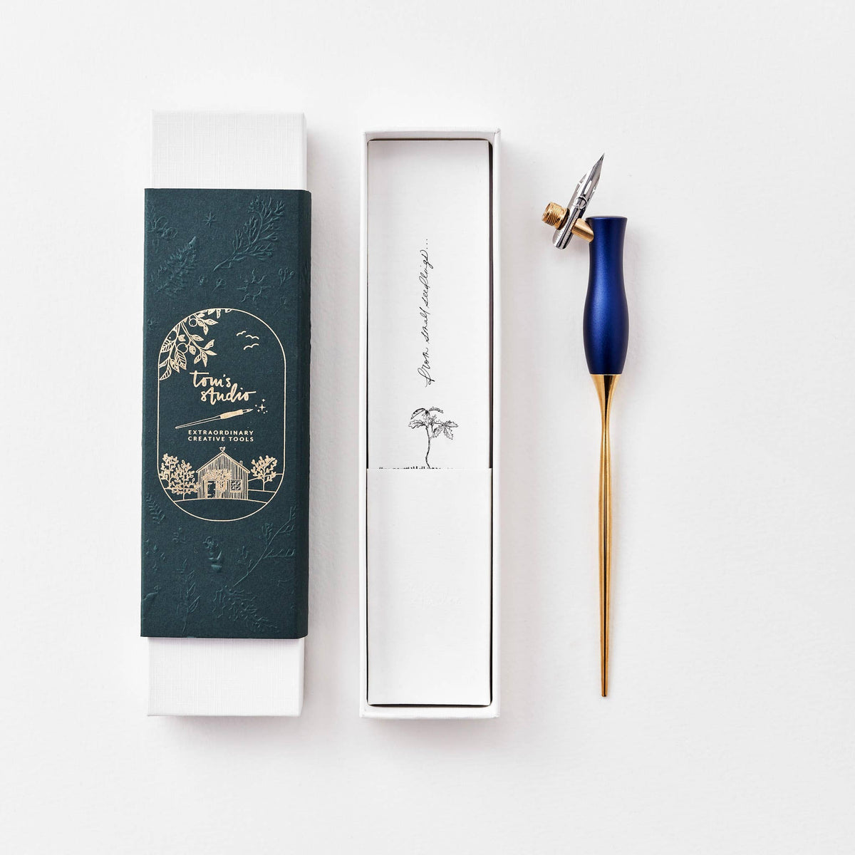 Calligraphy pen in dark teal with oblique nib and gold accents, shown with gift box
