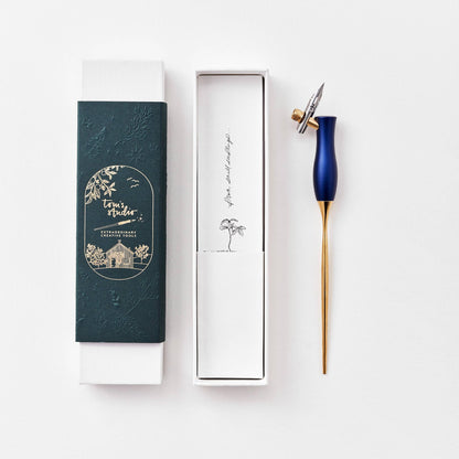 Calligraphy pen in dark teal with oblique nib and gold accents, shown with gift box