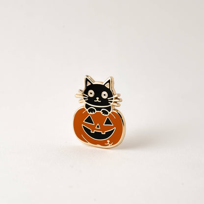 Halloween cat enamel pin with orange pumpkin face and jack-o’-lantern details