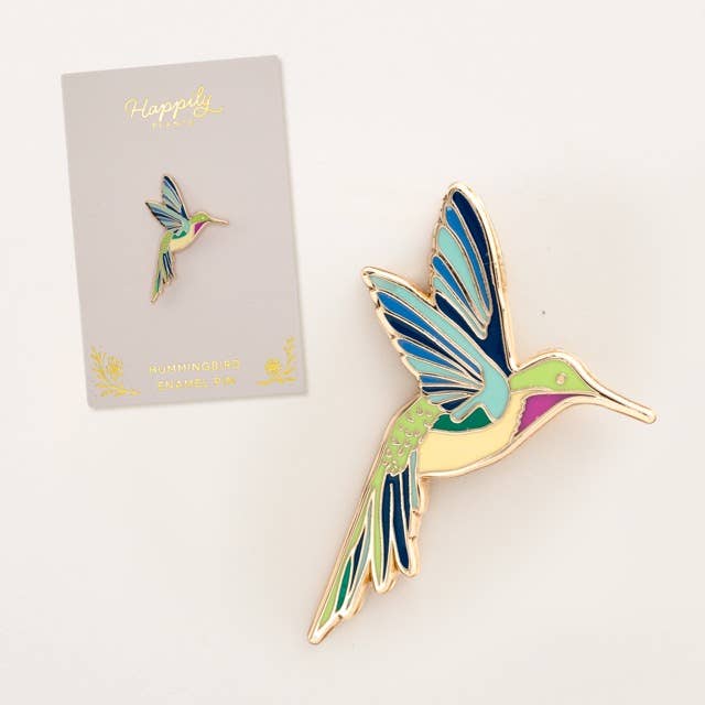 Hummingbird pin with a gold-tone frame next to a card display.