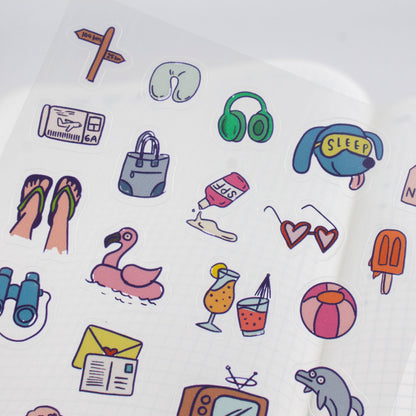 Close-up travel sticker sheet section with headphones, sleep cap, and surf icons