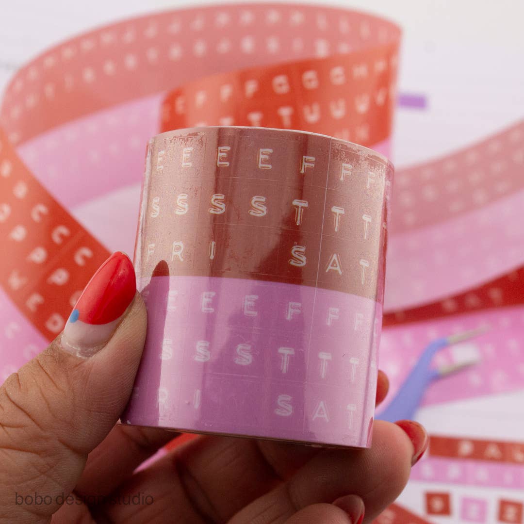 Kiss-cut PET tape roll with embossed letters, orange and pink translucent backing