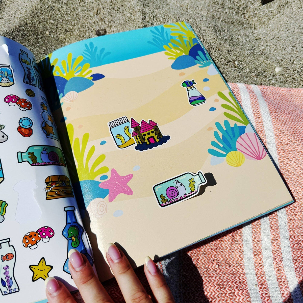 Sea life sticker book open to sticker sheet page with colorful sea-themed icons