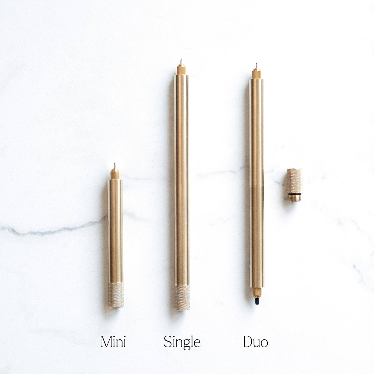 Three brass metal single-tip pens with pointed nibs