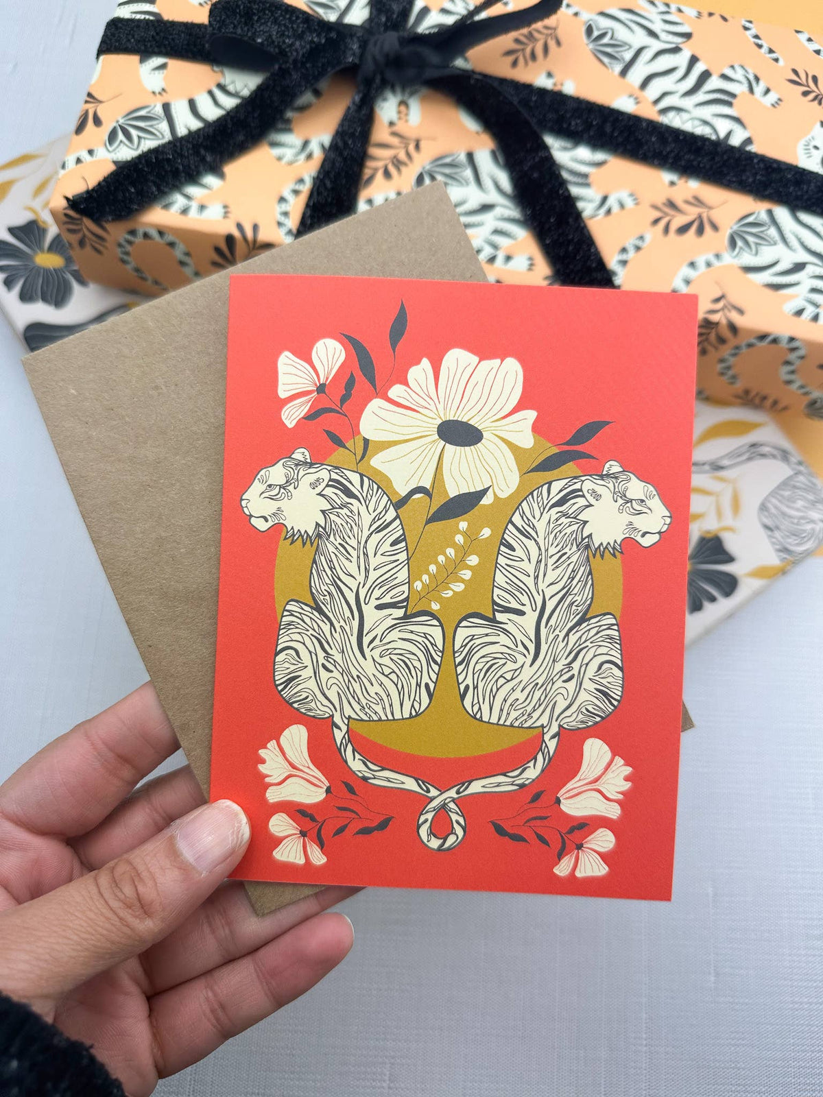 Coral greeting card with entwined tiger artwork and kraft envelope