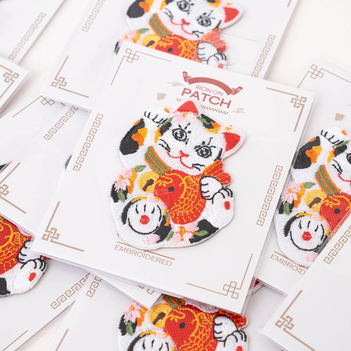 Lucky cat iron-on patch with embroidered koi fish, shown in close detail