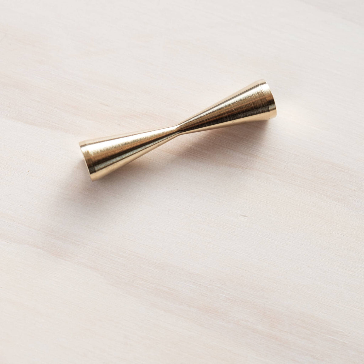 Brass pen rest with long tapered tube and rounded end cap, gold metallic finish