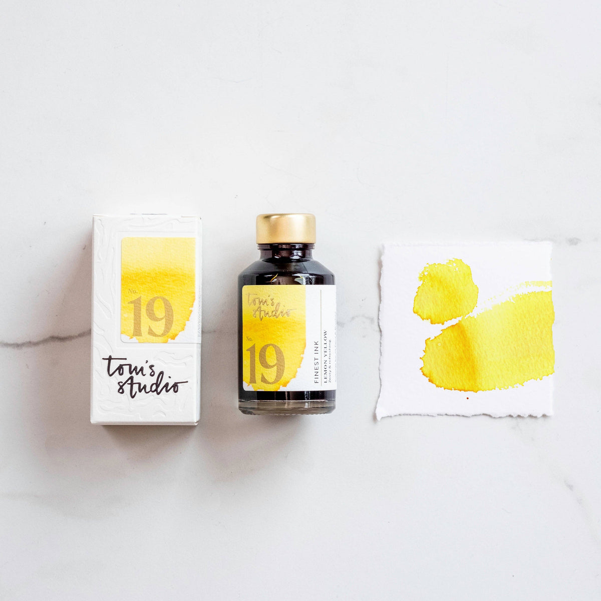 Fountain pen ink set with lemon yellow ink bottle, box, and ink color swatch